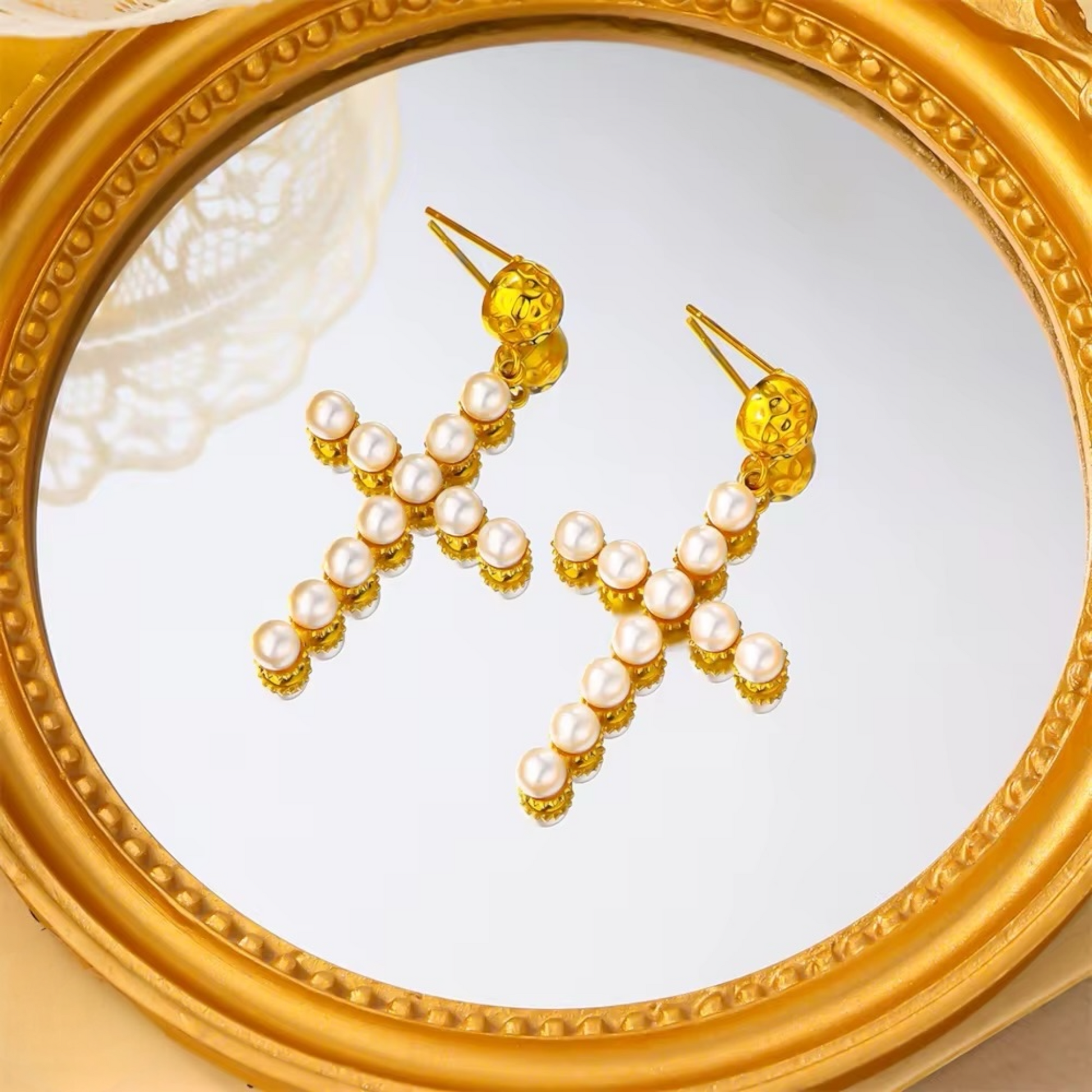 Cross pearl earrings flat lay on white background